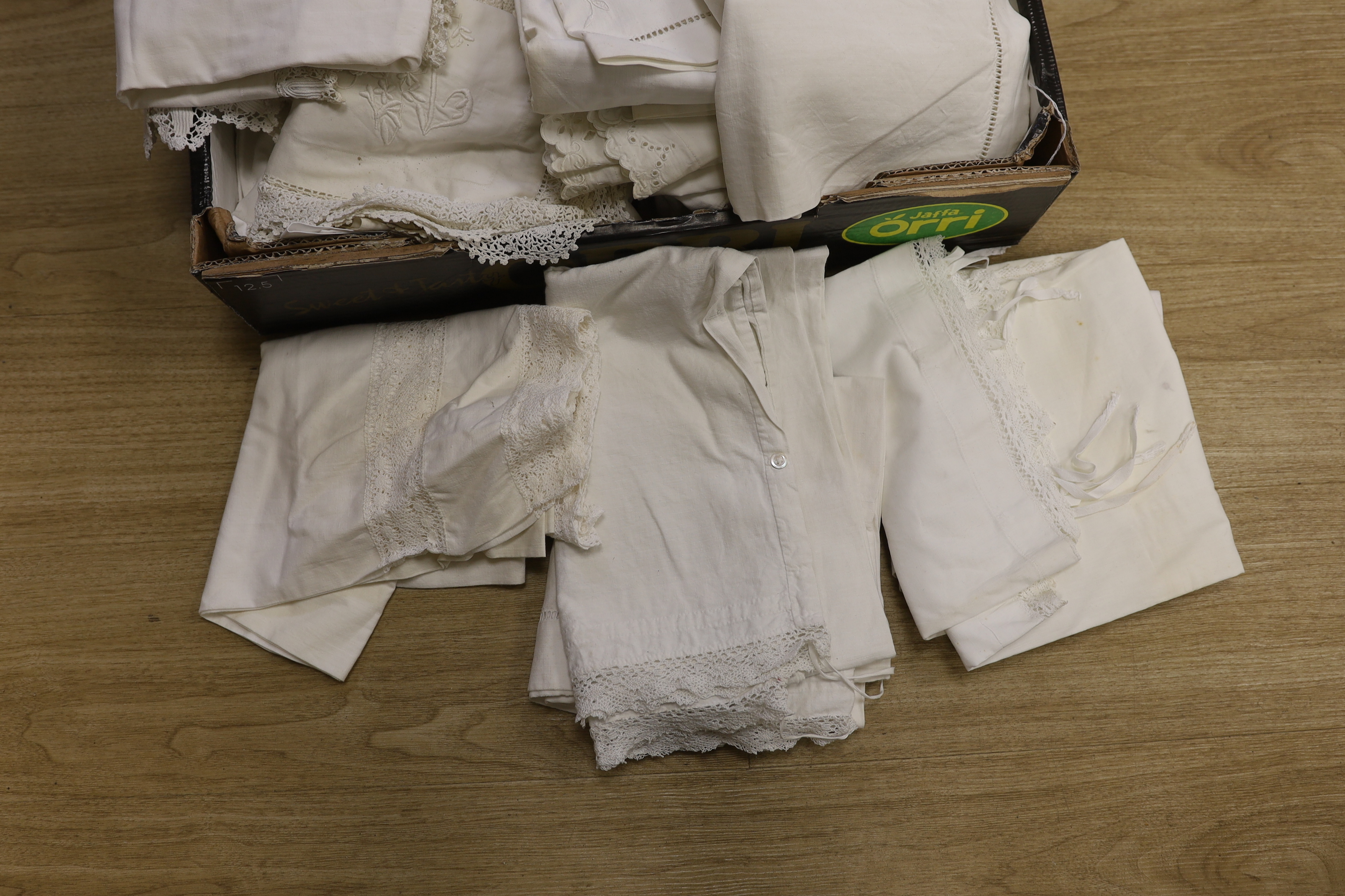 A large collection of French embroidered and crochet edged pillowcases and bolsters, some in pairs